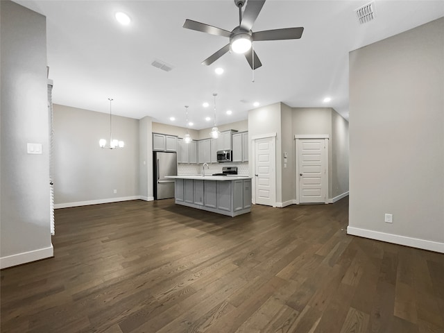 unfurnished living room with ceiling fan with notable chandelier, dark hardwood / wood-style floors, and sink