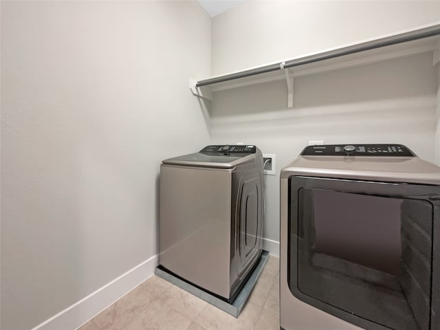 washroom featuring light tile floors and washer and dryer