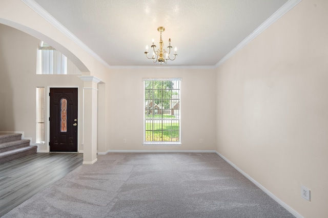 carpeted foyer entrance with a notable chandelier and ornamental molding