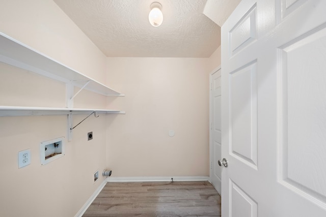 laundry room with hookup for an electric dryer, hookup for a washing machine, a textured ceiling, and light hardwood / wood-style floors