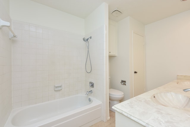 full bathroom featuring tiled shower / bath combo, tile flooring, vanity, and toilet