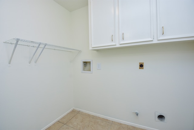 laundry area with electric dryer hookup, hookup for a washing machine, light tile floors, hookup for a gas dryer, and cabinets