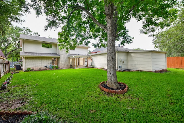 rear view of property featuring central AC and a yard