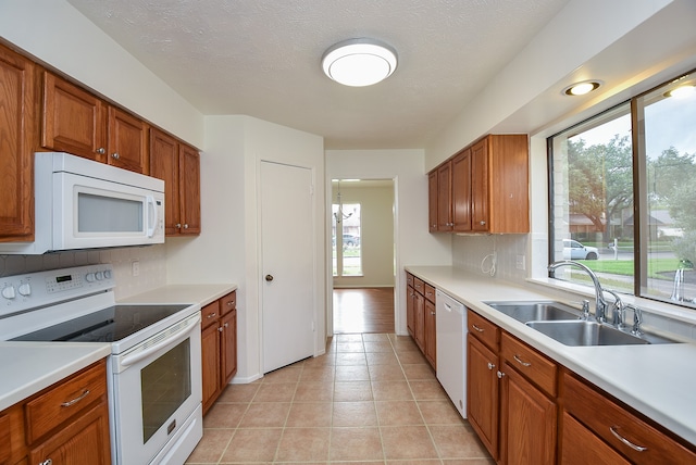 kitchen featuring plenty of natural light, white appliances, and light tile floors