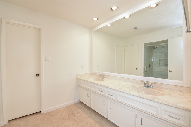 bathroom featuring an enclosed shower, vanity with extensive cabinet space, double sink, and tile flooring