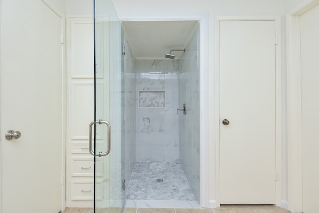 bathroom featuring tile floors and a shower with door