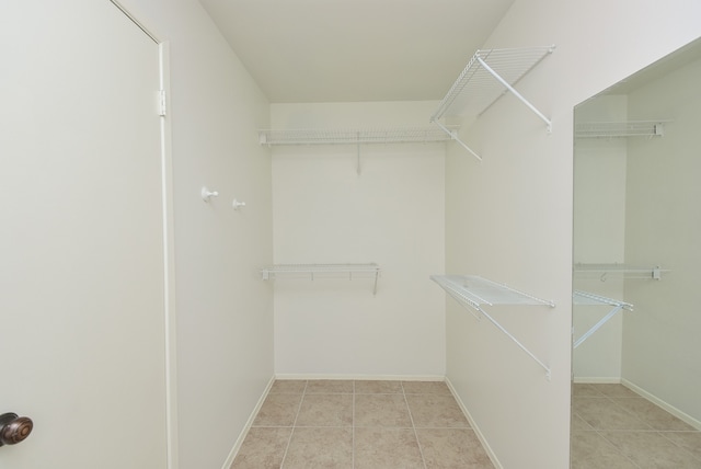 spacious closet with light tile flooring