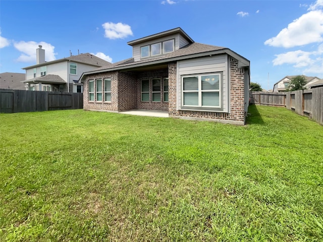 back of property with a patio area and a lawn