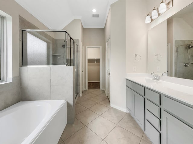 bathroom featuring plus walk in shower, crown molding, vanity with extensive cabinet space, and tile flooring