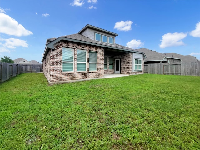 rear view of house featuring a patio and a lawn