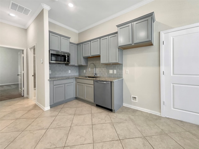 kitchen featuring ornamental molding, appliances with stainless steel finishes, backsplash, and light stone countertops