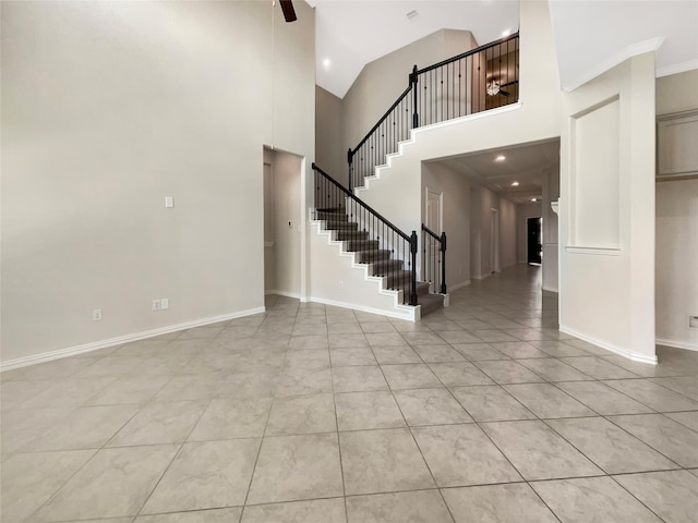 entryway with a towering ceiling and light tile floors