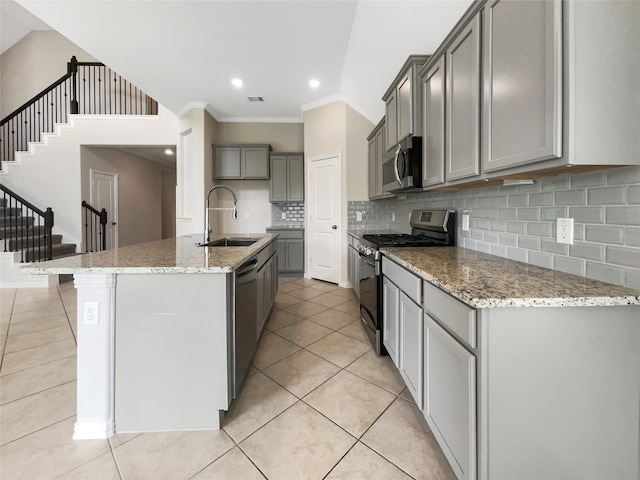 kitchen with appliances with stainless steel finishes, gray cabinets, crown molding, tasteful backsplash, and sink