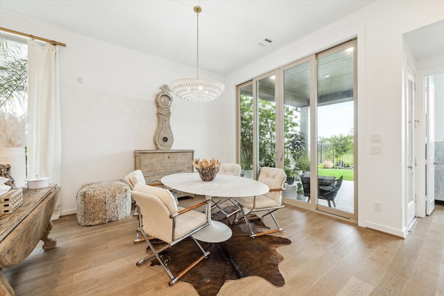 dining space with a chandelier and light hardwood / wood-style floors