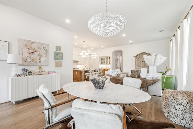 dining room featuring an inviting chandelier and light hardwood / wood-style flooring