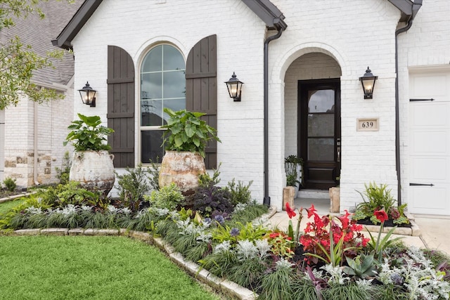 view of exterior entry featuring a lawn