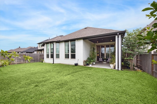 rear view of house featuring a patio area and a yard