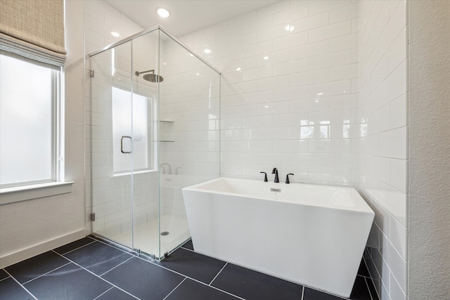 bathroom featuring tile walls, separate shower and tub, and tile floors