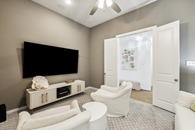 living room with light hardwood / wood-style flooring and ceiling fan