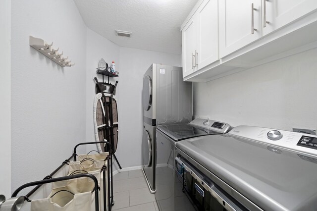 washroom with cabinets, a textured ceiling, and light tile floors