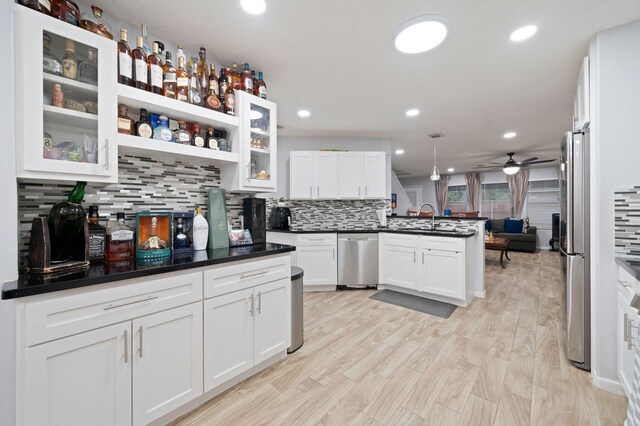 kitchen with decorative light fixtures, tasteful backsplash, white cabinetry, and appliances with stainless steel finishes