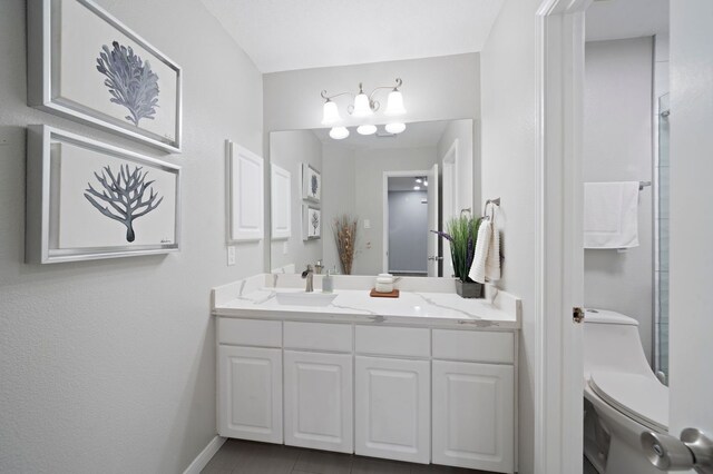 bathroom featuring tile floors, large vanity, and toilet