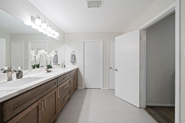 bathroom featuring tile floors, large vanity, and dual sinks