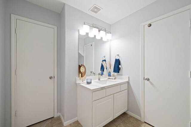 bathroom with tile flooring and vanity with extensive cabinet space