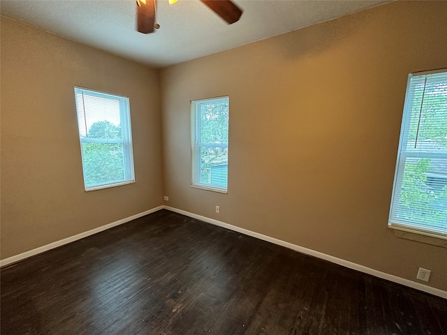 empty room with dark hardwood / wood-style flooring and ceiling fan