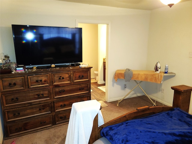 bedroom with light colored carpet and ensuite bathroom