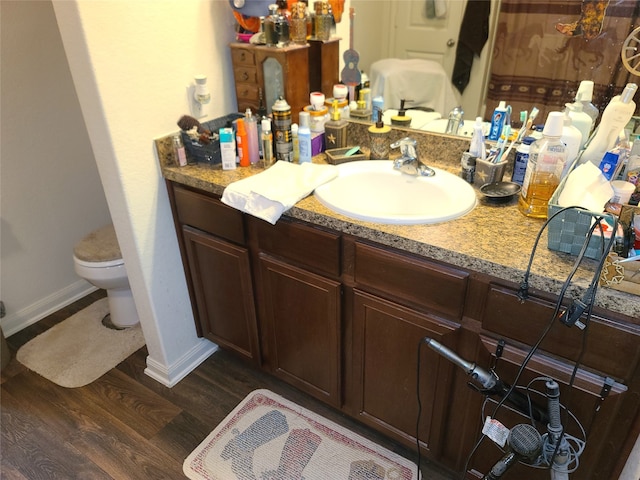 bathroom with oversized vanity, hardwood / wood-style floors, and toilet