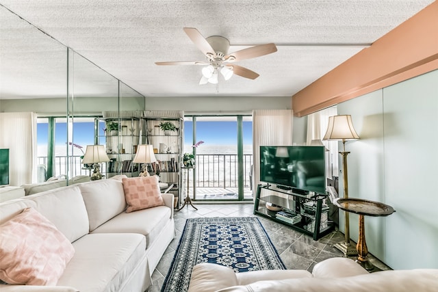 living room featuring tile flooring, ceiling fan, and a textured ceiling