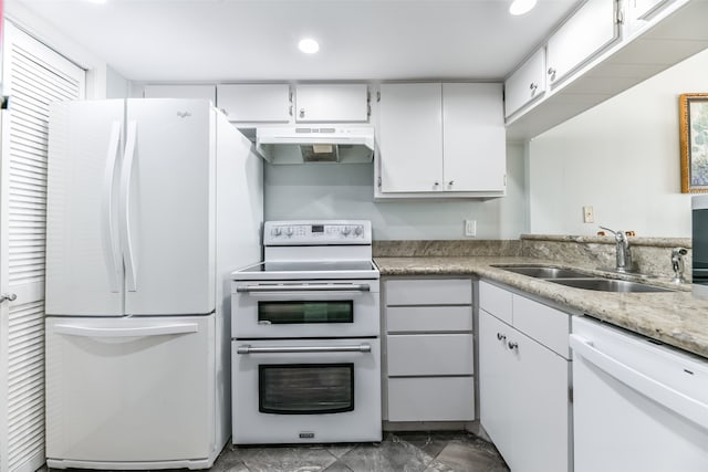 kitchen with white appliances, tile flooring, wall chimney range hood, white cabinetry, and sink