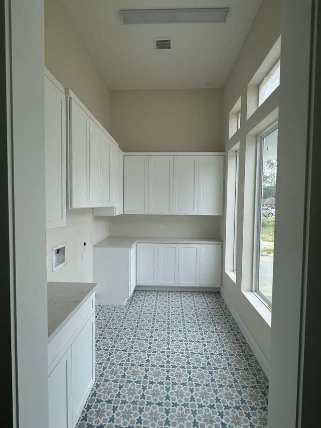 clothes washing area with cabinets and washer hookup