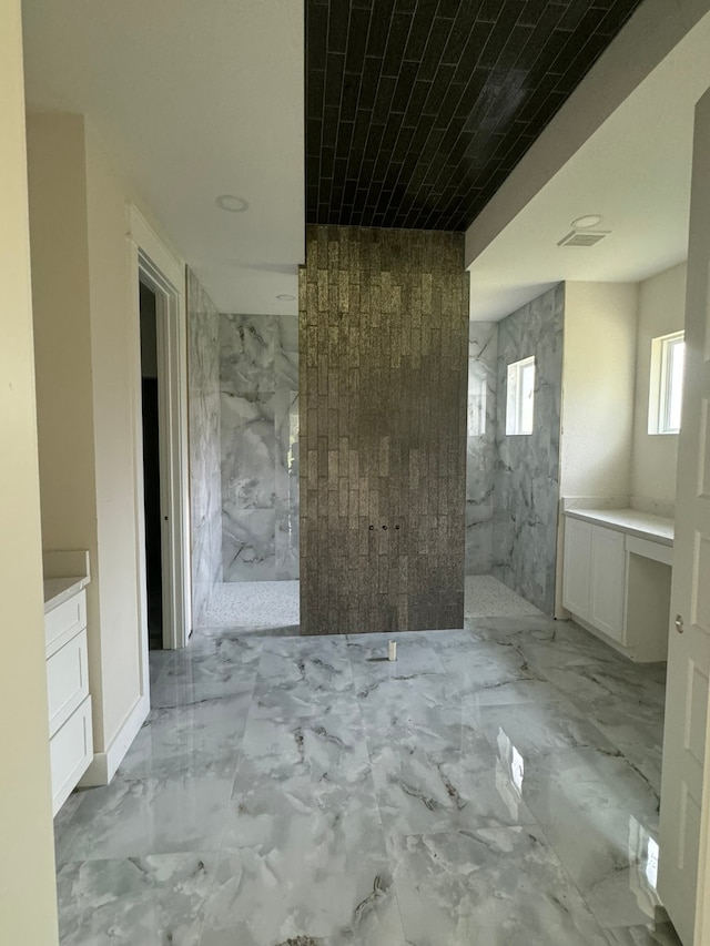 bathroom featuring walk in shower and vanity