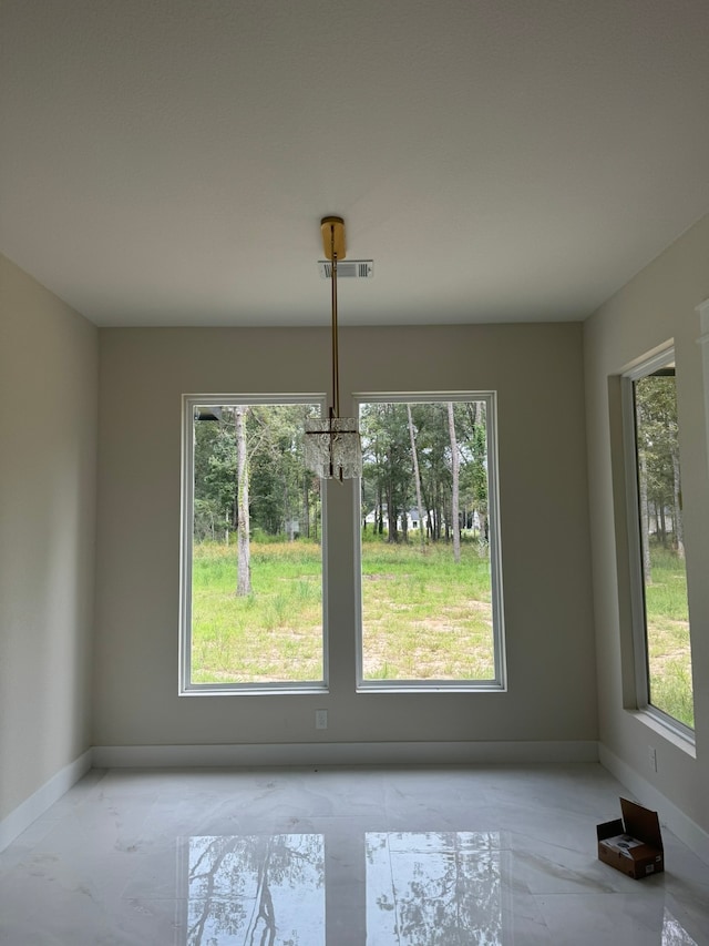 unfurnished dining area with plenty of natural light and a chandelier