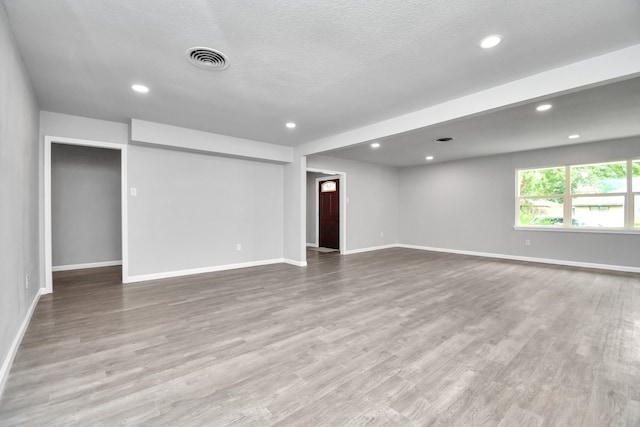 spare room featuring a textured ceiling and wood-type flooring