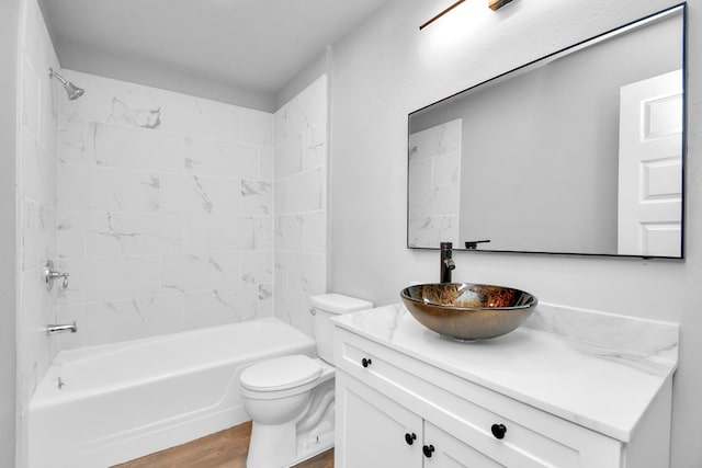 full bathroom with toilet, hardwood / wood-style floors, vanity, and tiled shower / bath