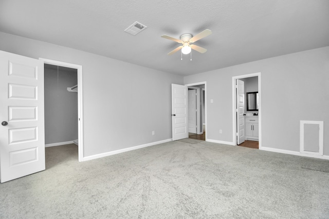 unfurnished bedroom featuring carpet flooring, connected bathroom, and a spacious closet