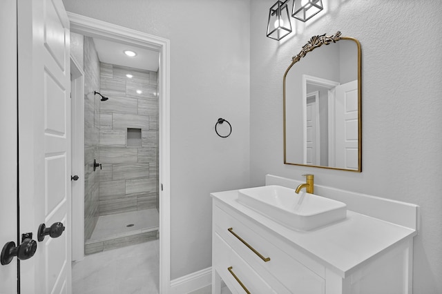 bathroom featuring vanity with extensive cabinet space and tiled shower