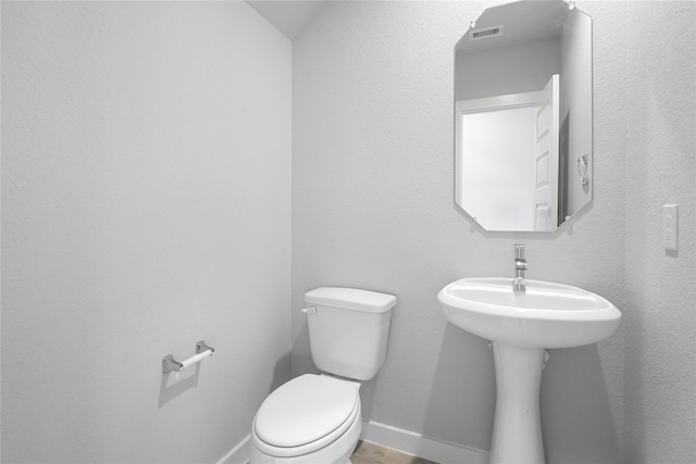 bathroom with baseboards, a sink, visible vents, and toilet