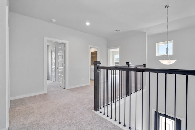 hallway featuring carpet floors, recessed lighting, an upstairs landing, and baseboards