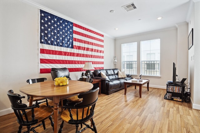 dining area featuring light hardwood / wood-style floors and crown molding