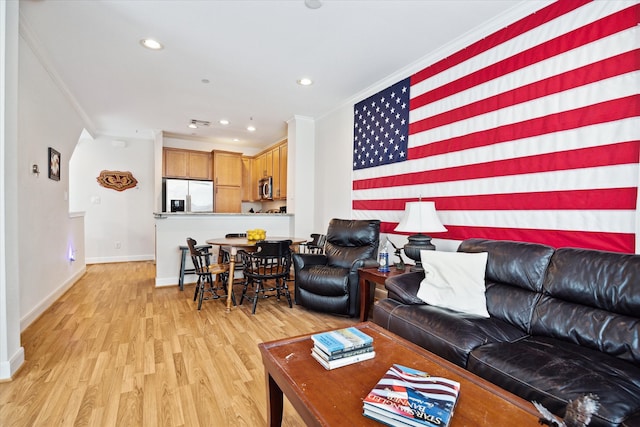 living room featuring light wood-type flooring and ornamental molding