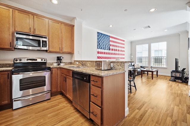 kitchen featuring light hardwood / wood-style flooring, sink, stainless steel appliances, and kitchen peninsula