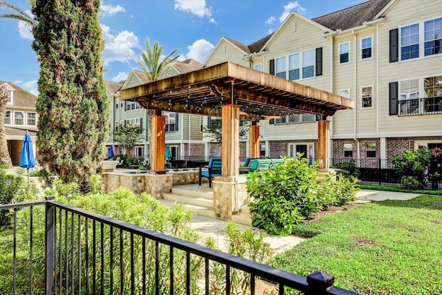 exterior space featuring a pergola, a balcony, and a lawn