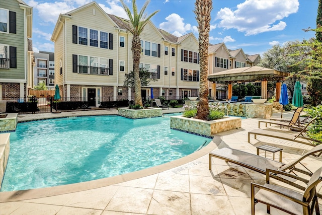 view of pool with pool water feature, a gazebo, and a patio