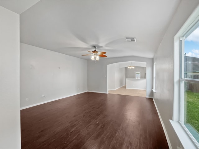 spare room with ceiling fan with notable chandelier, wood-type flooring, and lofted ceiling