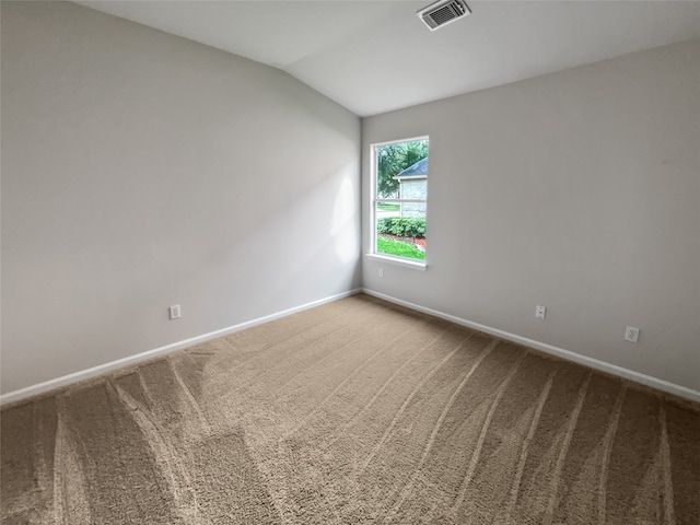 empty room featuring vaulted ceiling and carpet floors