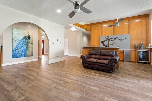 living room with ceiling fan, hardwood / wood-style flooring, and beverage cooler